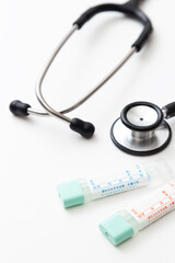白背景に検便キットと聴診器