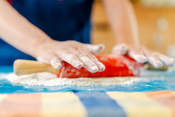 Obraz premium Chef using rolling pin, preparing dough on floured surface