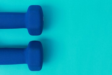 Two blue barbells on a blue background
