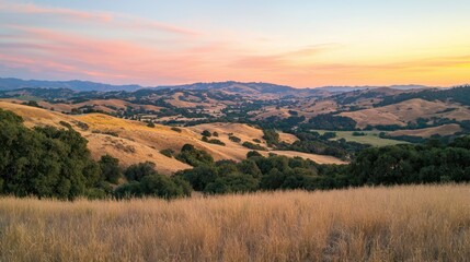 Obraz premium A serene countryside with rolling hills glowing under the warm orange light of sunset.