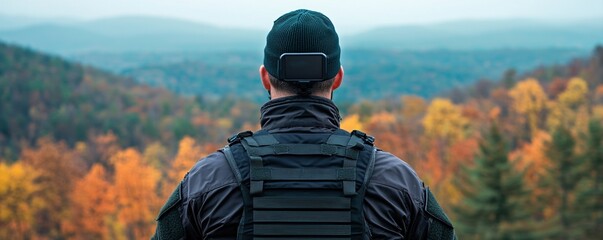 Military Contractor Operations Concepts. A person in tactical gear overlooking a colorful autumn landscape.