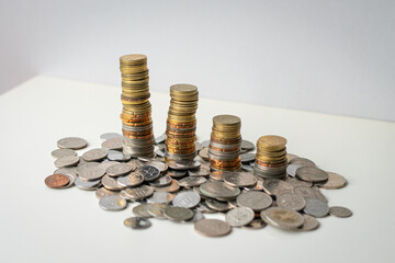 Coins stacked in a row, from high to low. Isolated on white surface. 