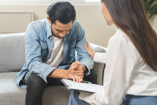 Psychology, depression. Sad asian young man consulting with psychiatrist while patient counseling mental therapy problem with doctor at clinic. Psychologist encouraging with sick mental health person.