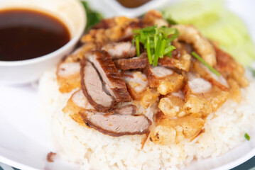 Crispy pork rice on a white plate on the dining table