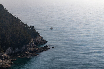 Obraz premium high-angle view of the cliff and fishing boat on the sea