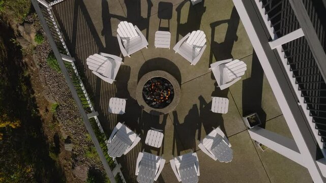 Adirondack chair surrounding Fire Pit on Luxury Pacific Ocean Costal Patio Top Down with Drone