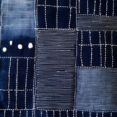 A Japanese sashiko stitch weave pattern with deep indigo fabric and white embroidery lines