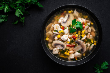 Spicy soup with chicken, mushrooms, corn, white beans, chili and cilantro. White background, top view
