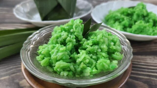 Green Sticky Rice Tape on a wooden table. It is a traditional Javanese Indonesian food with glutinous rice as the main ingredient or Oryza sativa L. Var. Glutinosa that is fermented.