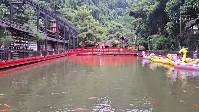 Bandung, indonesia February 28th 2025 : A serene Japanese pond with koi fish and traditional architecture