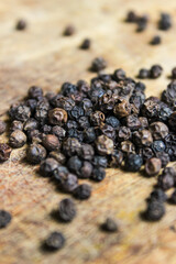 Black peppercorns with wood background. Food ingredients. Aromatic spice