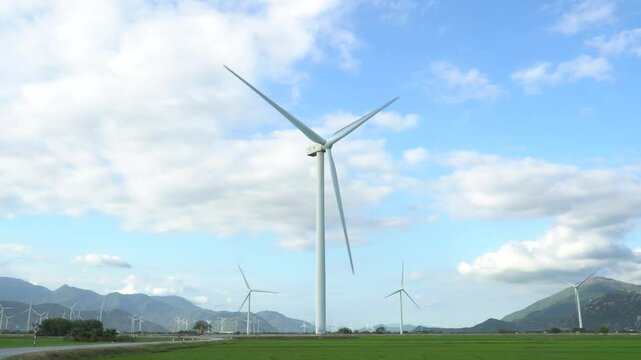 Wind turbines generating electricity on rice field at Phan Rang, Ninh Thuan, Vietnam. Clean energy concept. Windmill for electric power production. 4K video