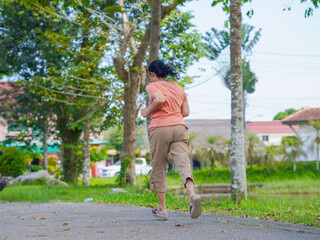 Obraz premium Lifestyle Health care. Elderly woman walking, running, exercise on walkway at park in morning. Health and a strong body from workout , jogging. Outdoor sports. People, environment, nature relax