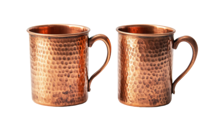 Two hammered copper mugs gleam against a black background. The warm tones and rustic texture make them perfect for a cozy drink.