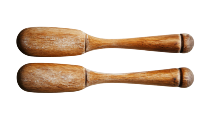 A pair of rustic wooden spoons, coated in a fine layer of flour, rests against a black background. The warm tones of the wood create a inviting mood.