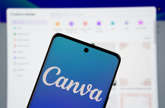 Dhaka, Bangladesh- 05 March 2025: Canva logo is displayed on a smartphone screen, with the canva website visible on a computer screen in the background.
