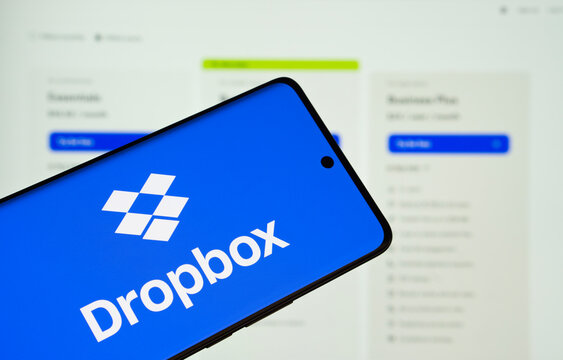 Dhaka, Bangladesh- 05 March 2025: Dropbox logo is displayed on a smartphone screen, with the dropbox website visible on a computer screen in the background.