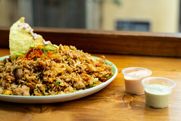 Fusion of Peruvian and Asian food called Arroz chaufa with jars of sauce.