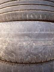 Close-up of worn tires with faded tread patterns. The rubber is smooth and weathered, indicating...
