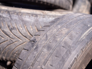 Close-up of worn tires with faded tread patterns. The rubber is smooth and weathered, indicating...