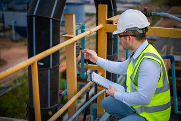 A professional plumbing engineer is checking a water filtration system at a factory to ensure that...