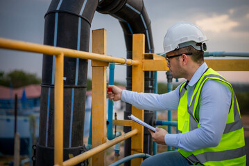 A professional plumbing engineer is checking a water filtration system at a factory to ensure that...
