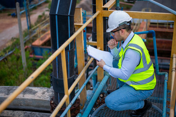 A professional plumbing engineer is checking a water filtration system at a factory to ensure that...