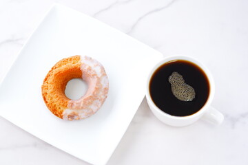砂糖でコーティングされたオールドファッションドーナツと、淹れたてのコーヒーでコーヒーブレイク
