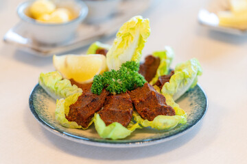 Raw meatballs, cig kofte from traditional Turkish cuisine. Delicious Turkish dish made with bulgur. Squeezed raw meatballs served with lemon and lettuce.