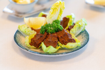 Raw meatballs, cig kofte from traditional Turkish cuisine. Delicious Turkish dish made with bulgur. Squeezed raw meatballs served with lemon and lettuce.