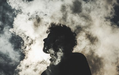 Silhouette of a man surrounded by swirling clouds during a dramatic sunset sky