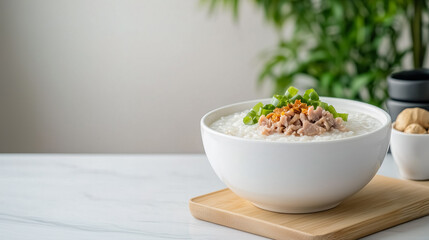 a bowl of delicious congee, a popular rice porridge, garnished with meat and green onion