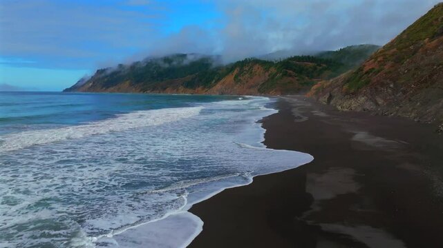 Sunny clear blue sky misty rugged surf rocky mountainside cliffs bluffs untouched remote USAL Beach campground California aerial drone camping Sinkyone Wilderness Lost Coast Trail forward upward
