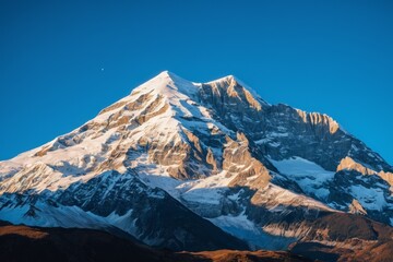 Obraz premium Snow covered mountains with a clear winter sky and rocky landscape