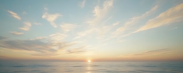 Fototapeta premium A beautiful sunrise reflecting on a tranquil ocean surface beneath clouds