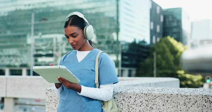 Headphones, doctor and woman student with tablet in city studying for clinical exam or test. Education, technology and female healthcare intern listening to music and reading online textbook in town