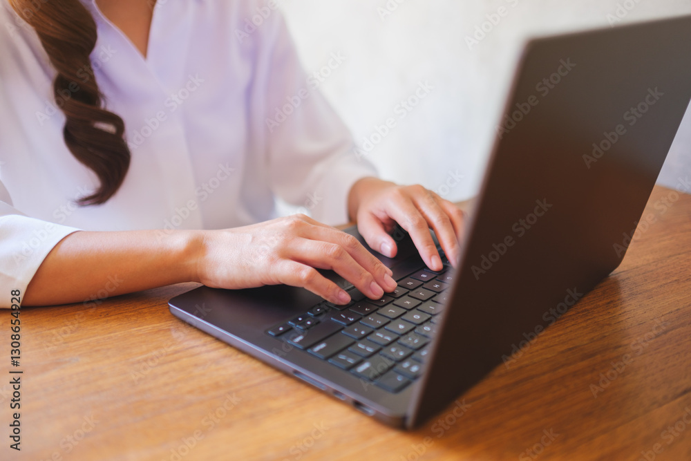Wall mural closeup image of a woman working and typing on laptop computer keyboard