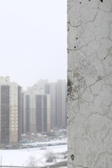 Abstract background vertical orientation with a defective wall and a heavily blurred background with multi-storey buildings on the left for text or insertion