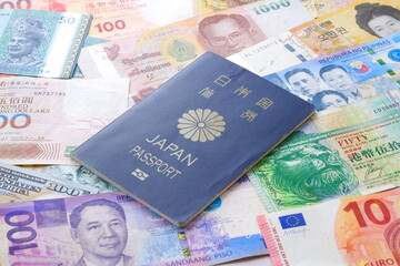 日本のパスポート（一般旅券5年用紺色）と海外のお金で、海外旅行のイメージ
