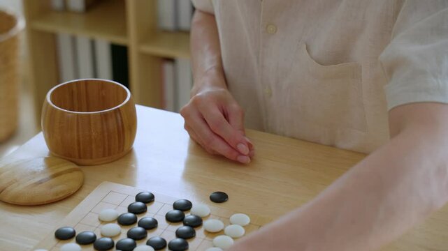 Close up of young men play board game Go during competition in community. 