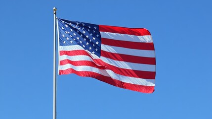 Fototapeta premium An American flag flies proudly against a clear blue sky. 