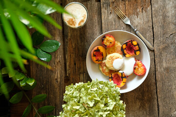 syrniki with cream, grilled peach and grilled plum