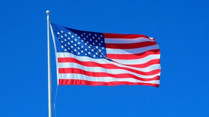 The American flag waving in a clear blue sky.
