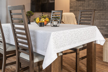 Modern dining table with white patterned tablecloth