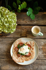 Flatbread with with black tomatoes, spinach and fried egg