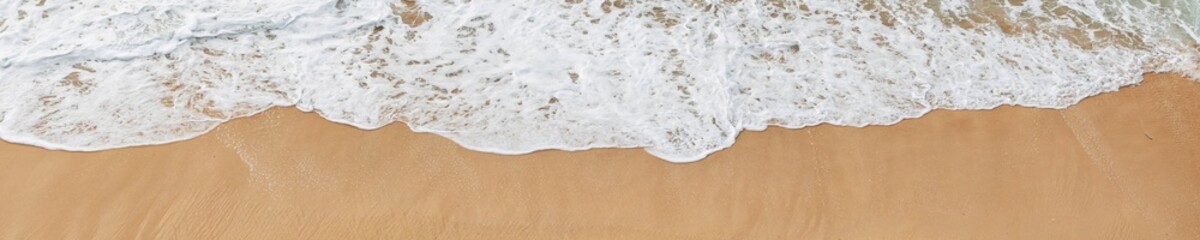 Soft ocean waves roll onto the sandy beach, creating delicate foam patterns. The rhythmic motion of water brings a sense of serenity.