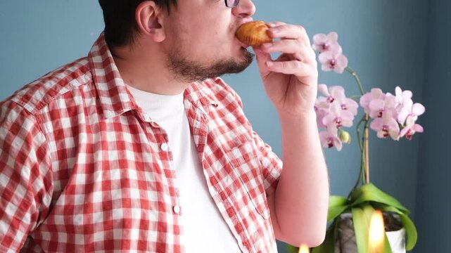closeup of man eating Easter cakes and drinking coffee on beautifully decorated Easter table