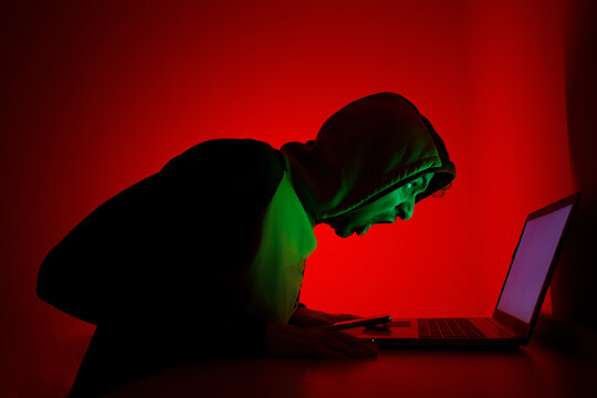 Intense Individual Yelling at Laptop Screen in Dark Room With Red Lighting
