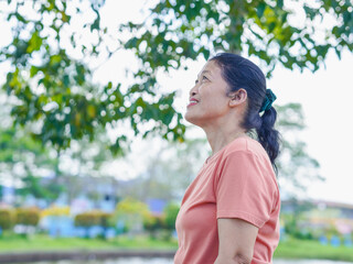 Lifestyle Health Care. Senior woman standing in nature with a happy smiling face. Outdoor activities and environment. Smiling people with a refreshing morning atmosphere and good mental health.