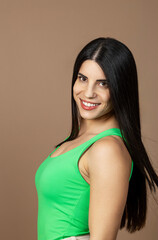 Obraz premium Elegant woman with long black hair, beaming while posing in a studio portrait